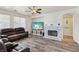 Cozy living room with a stone fireplace, large windows, neutral walls, and wood-look floors at 564 Lampshire Ln, Pahrump, NV 89060