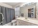 Bathroom featuring a shower-tub combo, white vanity with marble countertop and ample lighting at 5862 Bluthe Bridge Ave, Las Vegas, NV 89141