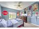 Cozy bedroom with carpet, lots of artwork and a ceiling fan providing comfortable living space at 5862 Bluthe Bridge Ave, Las Vegas, NV 89141