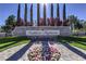 Elegant community entrance with stone signage, manicured landscaping, and floral accents at 5862 Bluthe Bridge Ave, Las Vegas, NV 89141
