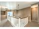 Upstairs hallway with natural lighting, neutral paint, and a view of the downstairs living area at 5862 Bluthe Bridge Ave, Las Vegas, NV 89141