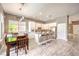 Bright kitchen with white cabinetry, stainless steel appliances, large island and adjacent dining area with backyard view at 5862 Bluthe Bridge Ave, Las Vegas, NV 89141