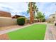Large artificial turf backyard with putting green and mature landscaping at 6214 Ebony Legends Ave, Las Vegas, NV 89131