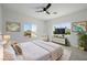 Bright bedroom featuring dual windows, a ceiling fan, and neutral decor at 6214 Ebony Legends Ave, Las Vegas, NV 89131