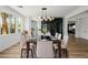 Modern dining room showcasing a glass-top table, statement lighting, and a sleek glass-enclosed wine cellar at 6214 Ebony Legends Ave, Las Vegas, NV 89131