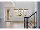 Bright entryway with wood floors, black iron staircase, and large windows overlooking palm trees at 6214 Ebony Legends Ave, Las Vegas, NV 89131