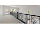 Bright hallway with decorative iron railing, white walls, neutral carpet and natural light from windows and a door to the outside at 6214 Ebony Legends Ave, Las Vegas, NV 89131