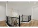 Hallway with hardwood floors and ornate railing overlooking the lower level with a modern chandelier at 6214 Ebony Legends Ave, Las Vegas, NV 89131