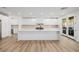 Spacious modern kitchen with a large central island, white cabinets, and stainless steel appliances at 6214 Ebony Legends Ave, Las Vegas, NV 89131