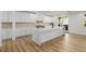 Modern kitchen featuring a large island with waterfall countertop, white cabinets, and stainless appliances at 6214 Ebony Legends Ave, Las Vegas, NV 89131