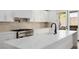 Modern kitchen features a large island with waterfall countertop, white cabinets, and stainless appliances at 6214 Ebony Legends Ave, Las Vegas, NV 89131