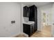 Laundry room with dark cabinetry, a utility sink and entry to the house at 6214 Ebony Legends Ave, Las Vegas, NV 89131