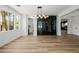 Bright living room features a unique wine storage area, modern light fixture, and wood flooring at 6214 Ebony Legends Ave, Las Vegas, NV 89131
