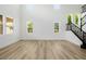 Spacious living room with tall ceilings, many windows, wood floors, and decorative staircase at 6214 Ebony Legends Ave, Las Vegas, NV 89131