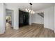 Bright living room features a unique wine storage area, modern light fixture, and wood flooring at 6214 Ebony Legends Ave, Las Vegas, NV 89131