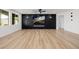 Bright, open living room with sleek black accent wall, modern fireplace, and hardwood floors at 6214 Ebony Legends Ave, Las Vegas, NV 89131