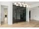 Bright living room features a unique wine storage area, modern light fixture, and wood flooring at 6214 Ebony Legends Ave, Las Vegas, NV 89131