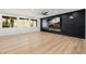 Bright, open living room with sleek black accent wall, modern fireplace, and hardwood floors at 6214 Ebony Legends Ave, Las Vegas, NV 89131