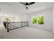 Upstairs loft area with ample space, natural light, black iron railing, and ceiling fan at 6214 Ebony Legends Ave, Las Vegas, NV 89131