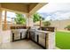 Covered outdoor kitchen with stainless steel grill and stone backsplash at 6214 Ebony Legends Ave, Las Vegas, NV 89131