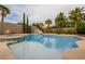 An inviting pool and spa with a slide provide an outdoor oasis with palm trees and mature landscaping at 6214 Ebony Legends Ave, Las Vegas, NV 89131