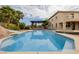 Backyard pool with slide, covered seating area, and a large house in the background at 6214 Ebony Legends Ave, Las Vegas, NV 89131