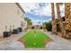 Backyard putting green with brick borders, flags and palm trees at 6214 Ebony Legends Ave, Las Vegas, NV 89131