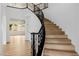 Elegant curved staircase with wrought iron railing and wood steps at 6214 Ebony Legends Ave, Las Vegas, NV 89131