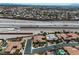 Wide aerial view of neighborhood featuring houses with pools, desert landscaping, and proximity to the highway at 6227 Orto Vaso Ave, Las Vegas, NV 89131