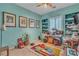 A room painted turquoise and used for hobbies, featuring a window with white shutters and shelving at 6227 Orto Vaso Ave, Las Vegas, NV 89131