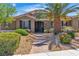 Inviting home exterior with manicured landscaping, decorative iron gate, and brick pathway at 6227 Orto Vaso Ave, Las Vegas, NV 89131