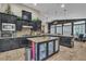 Open kitchen with dark cabinetry, a spacious island, and stainless steel appliances at 6227 Orto Vaso Ave, Las Vegas, NV 89131