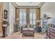 Living room showcasing neutral tones, plantation shutters, decoratively draped windows, and a tiled fireplace at 6227 Orto Vaso Ave, Las Vegas, NV 89131