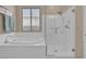 Bright bathroom featuring a soaking tub and a glass-enclosed shower at 6567 American Eagle Ave, Las Vegas, NV 89131