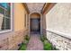 Inviting entryway with a stone-paved walkway and a double-door entrance, flanked by lush greenery and sconces at 6567 American Eagle Ave, Las Vegas, NV 89131