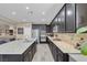Kitchen featuring a large island with seating, dark cabinets, and granite countertops at 6567 American Eagle Ave, Las Vegas, NV 89131
