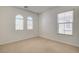 Bright bedroom with neutral carpet, white walls, and natural light from two arched windows at 6622 Colorado Spruce St, Las Vegas, NV 89149