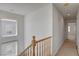 Second story hallway with carpet flooring, windows, and a wooden railing staircase at 6622 Colorado Spruce St, Las Vegas, NV 89149