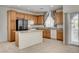 Spacious kitchen boasts wood cabinets, granite counters, stainless steel fridge, and island at 6622 Colorado Spruce St, Las Vegas, NV 89149