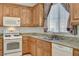 Well-lit kitchen featuring white appliances and granite countertops and wood cabinets at 6622 Colorado Spruce St, Las Vegas, NV 89149