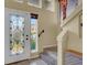 View of the home's foyer with decorative door, staircase, and tile floors at 6726 Glissando Ct, Las Vegas, NV 89139