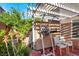 Serene covered patio with a pull-up bar and workout bench overlooking the lush yard at 6726 Glissando Ct, Las Vegas, NV 89139