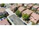 This aerial view showcases the neighborhood and a neatly landscaped home with mature trees and a neutral color scheme at 7042 Grand Junction Ave, Las Vegas, NV 89179