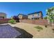 Spacious backyard with minimal landscaping, brick privacy wall, and a brick patio at 7042 Grand Junction Ave, Las Vegas, NV 89179
