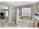 Bright bathroom with double vanity, separate shower, and soaking tub with glass block window at 7042 Grand Junction Ave, Las Vegas, NV 89179