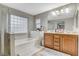 Bright bathroom with double vanity, separate shower, and soaking tub with glass block window at 7042 Grand Junction Ave, Las Vegas, NV 89179