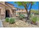 Landscaped front yard with stone accents and desert-friendly foliage and a covered front porch at 7042 Grand Junction Ave, Las Vegas, NV 89179
