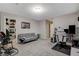 Spacious and bright living room with a modern desk, plush carpet, and neutral wall paint at 7042 Grand Junction Ave, Las Vegas, NV 89179