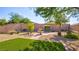 Landscaped backyard with a lovely fountain, artificial grass, mature trees, and a peaceful, park-like setting at 711 Golden Sedum Dr, Henderson, NV 89011