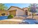 Charming single-story home featuring a two-car garage, neutral stucco, low maintenance landscaping, and an arched entryway at 711 Golden Sedum Dr, Henderson, NV 89011